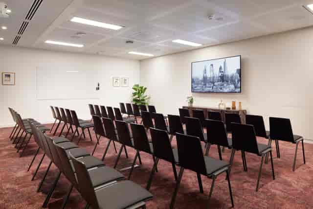 Ivory Studio meeting room with black chairs, perfect for conferences and presentations.