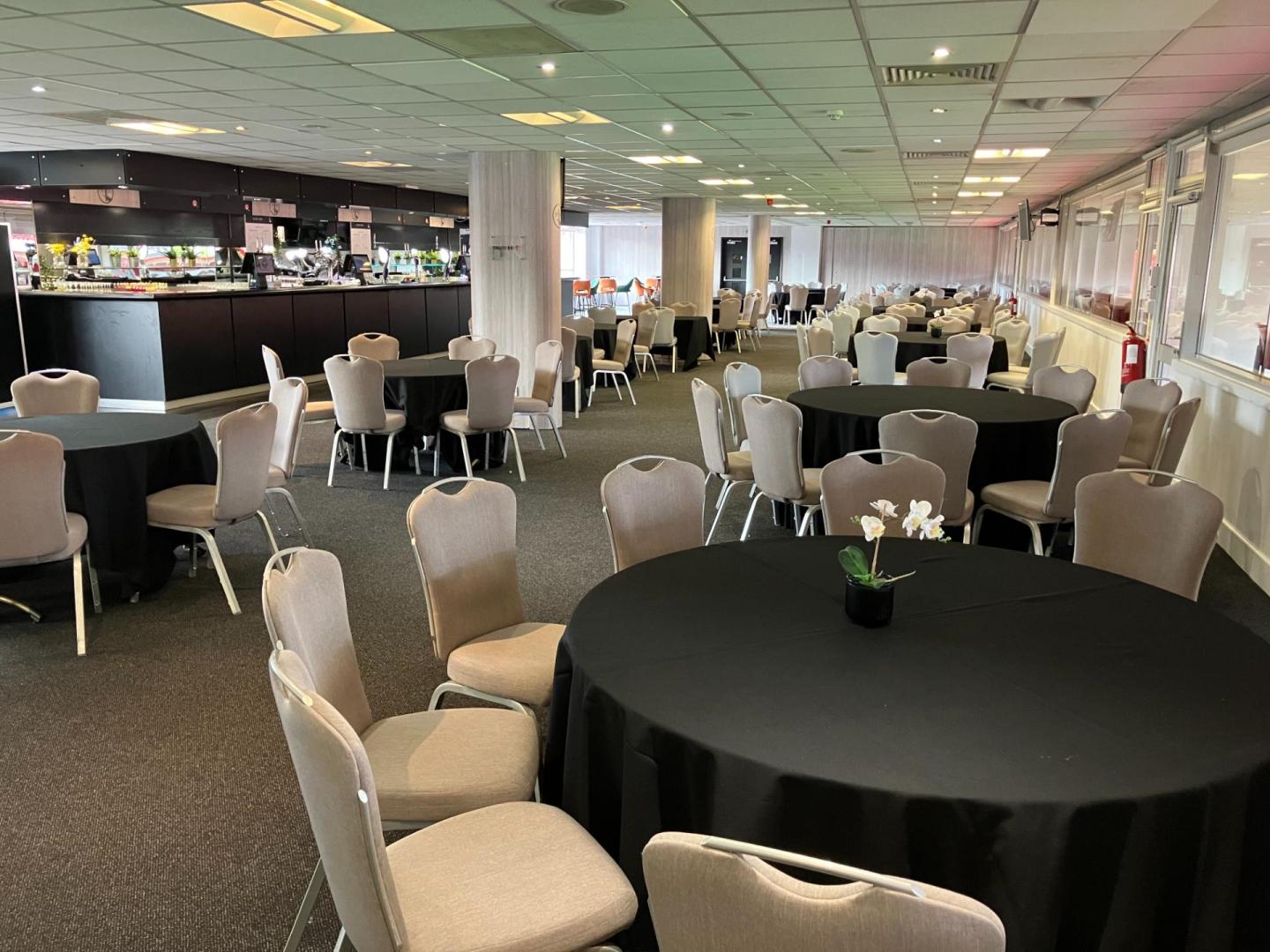 Club 1905 Lounge at Charlton Athletic, elegant event space with round tables for gatherings. - Banner