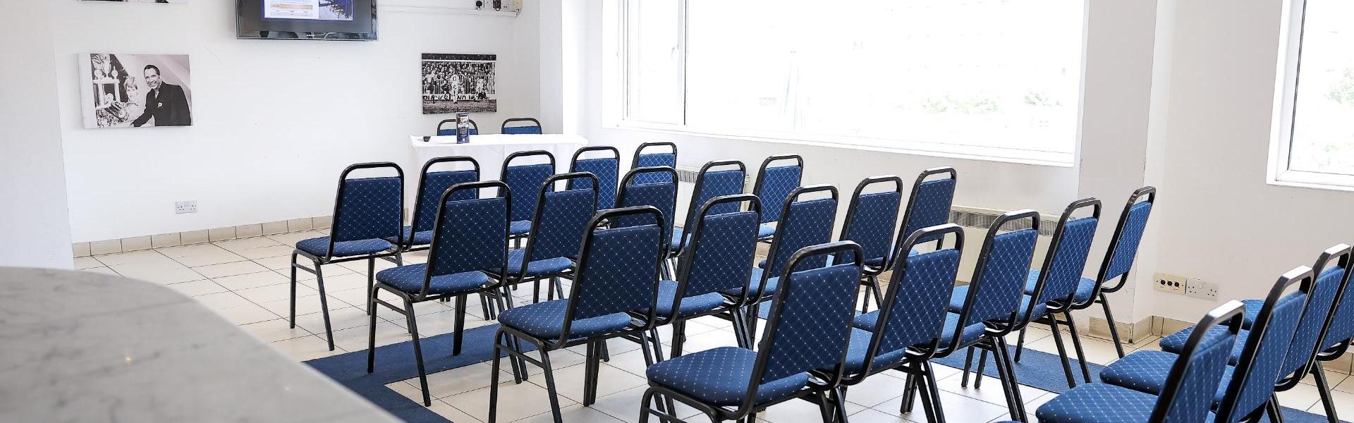 David Seaman Suite at Peterborough United FC, blue chairs setup for corporate meeting event.