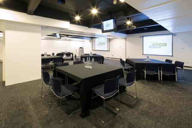 Modern Seminar Suites with tables and presentation screens for corporate events.