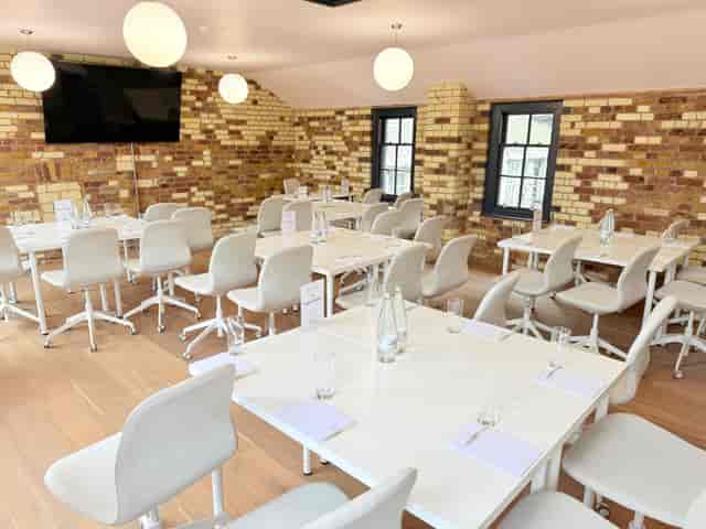 Meeting Room 308 boardroom setup with exposed brick, ideal for professional workshops and meetings.