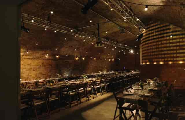 "Charming Kachette venue with wooden tables and ambient lighting for events and gatherings."