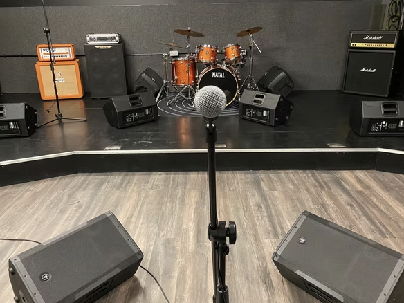 Rehersals Studios stage setup with microphone and drum kit for live concerts.