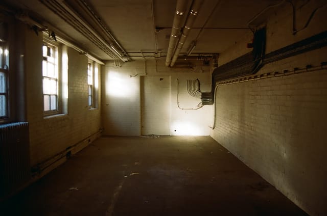 Empty, well-lit event venue with exposed pipes; perfect for creative setups and minimalistic themes.