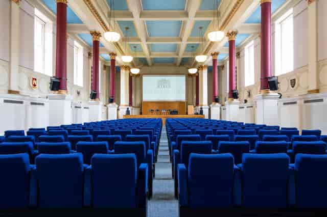 Low-Impact DDR event hall with blue chairs, perfect for conferences and seminars.