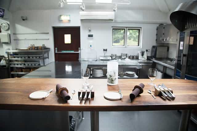 Kitchen bench at Restaurant Sat Bains, elegant setting for cooking demonstrations and events.