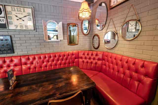 Cozy red leather booth in The Larwood & Voce, ideal for meetings and gatherings.