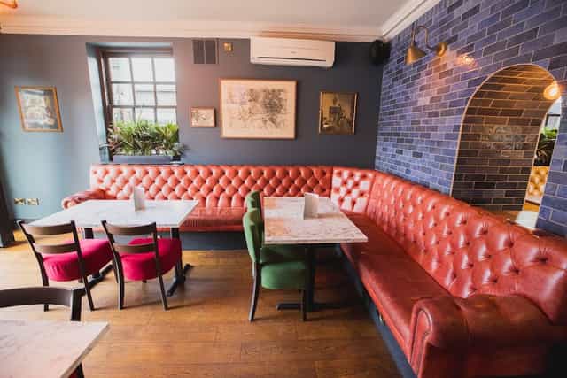 Stylish meeting space in Ye Olde Trip to Jerusalem with vibrant red banquette, ideal for networking.