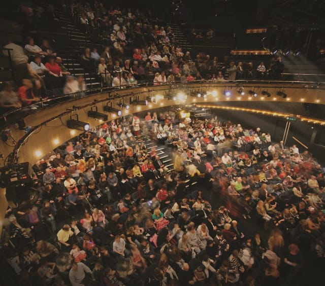 Main Stage at Nottingham Playhouse with engaged audience in vibrant theater setting.