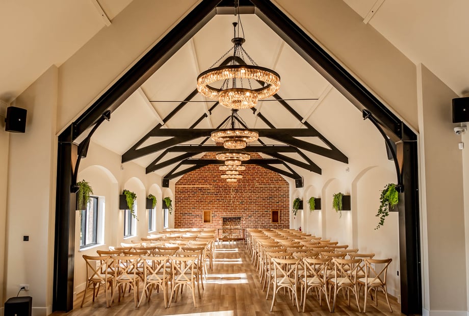 Spacious meeting room with elegant chandeliers, ideal for corporate events and weddings. - Banner