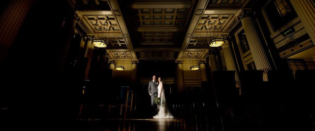 Elegant wedding ceremony at Nottingham Playhouse with ornate architecture and warm lighting.
