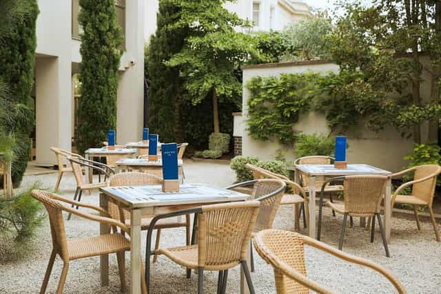 Outdoor event courtyard at Hart's Hotel & Kitchen, featuring tables, greenery, and dining options.