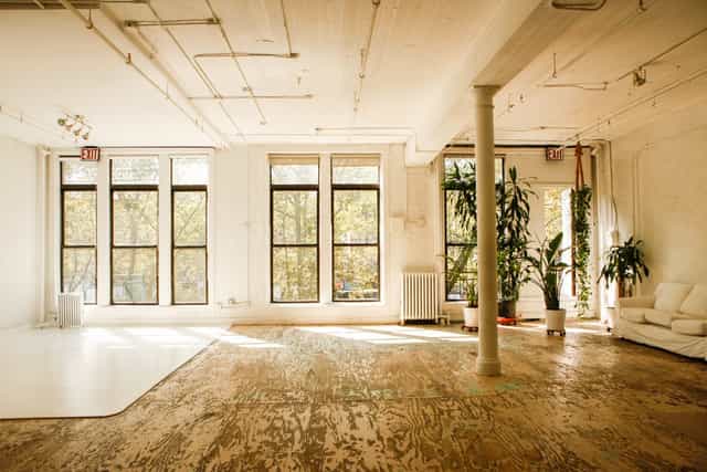 Spacious meeting room with natural light and greenery, ideal for workshops and events.