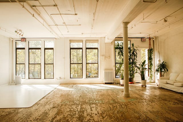 Spacious meeting room with natural light and greenery, ideal for workshops and events.