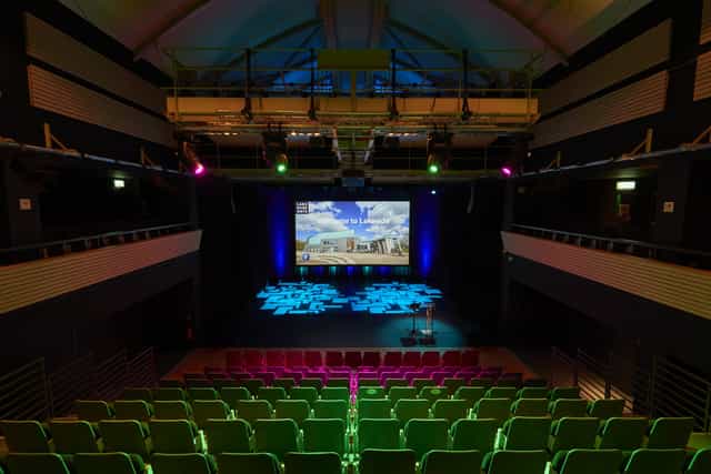 Djanogly Theatre conference space with tiered seating and vibrant lighting for presentations.