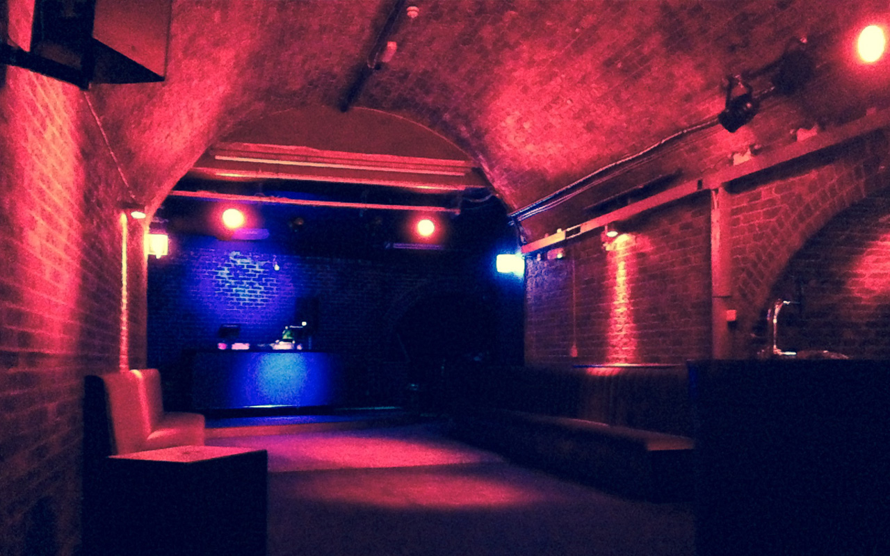 Rustic event space with exposed brick walls and atmospheric lighting in London.