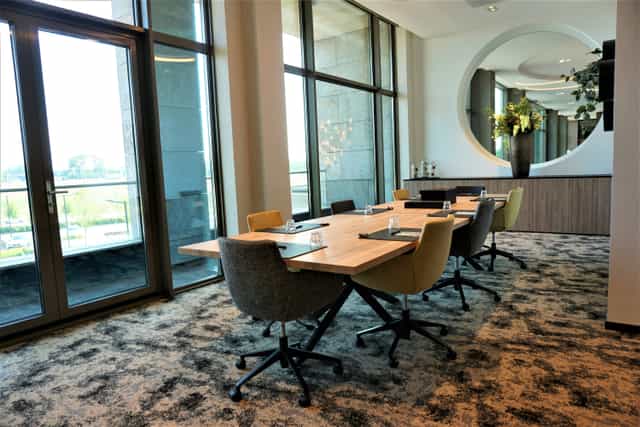 Modern multifunctional meeting room with large windows, ideal for corporate events and collaboration.