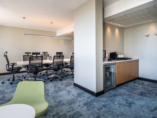Boardroom-style meeting space at Crowne Plaza Antwerp with integrated refreshment station.