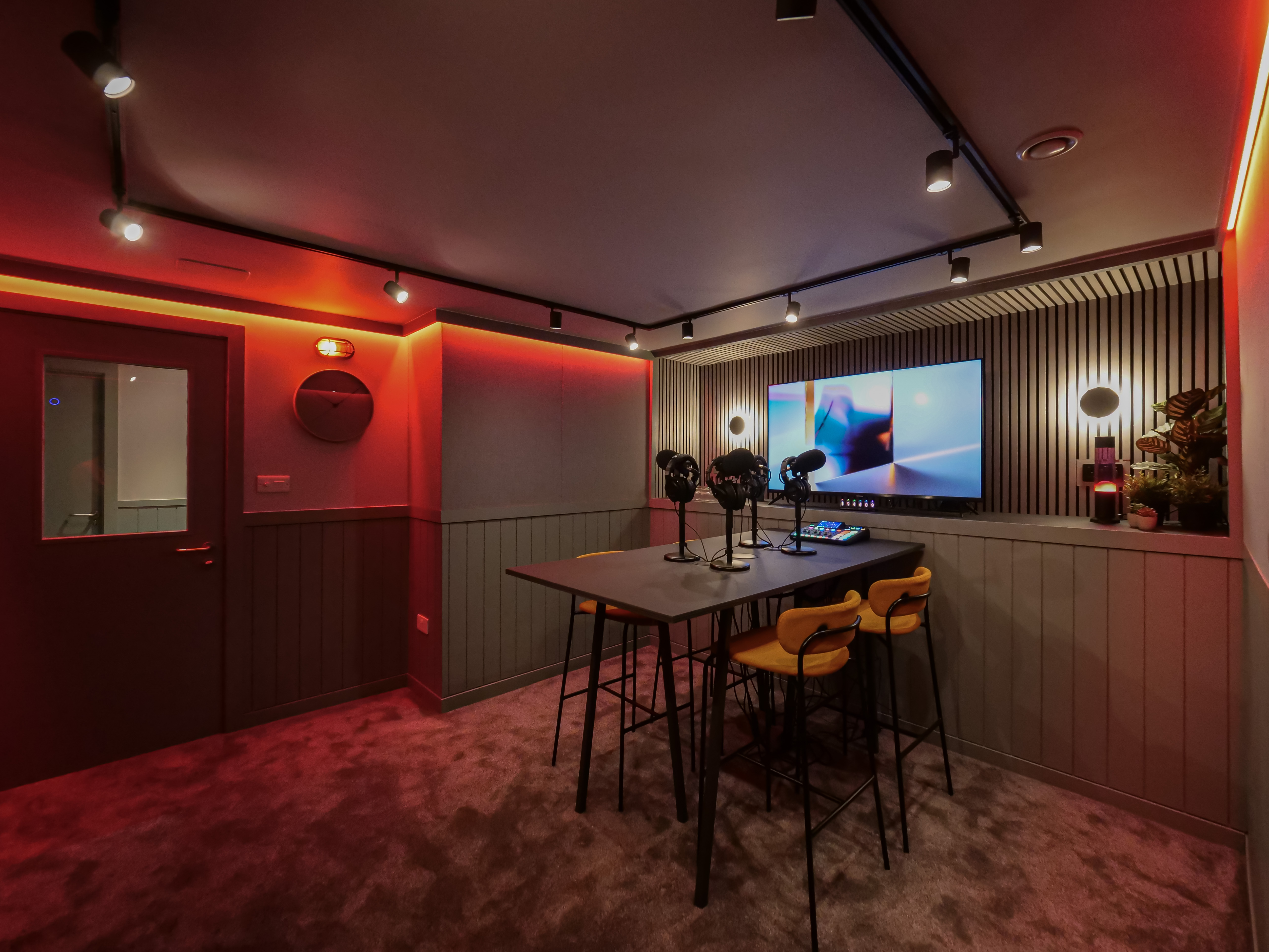 Modern podcast room in Colony Jactin House, featuring a large screen for presentations.