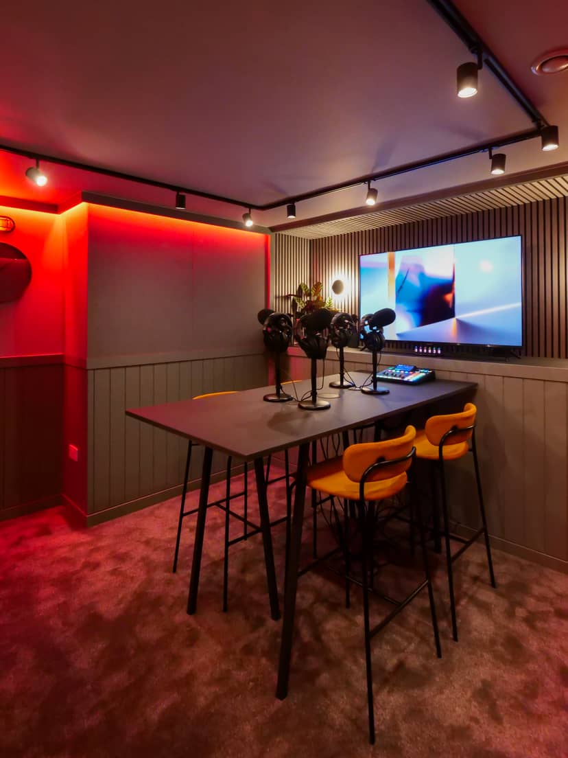 Modern podcast room with vibrant chairs and microphones for creative meetings.