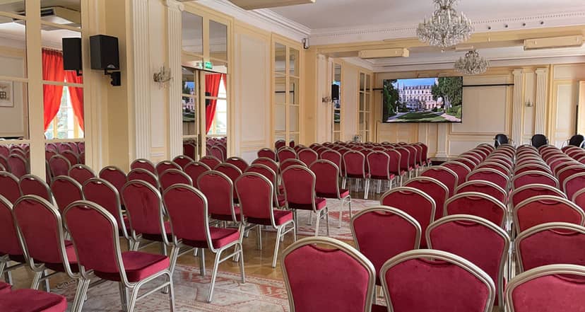 Seminar setup in Maison de l'Amérique Latine with red chairs and large presentation screen.