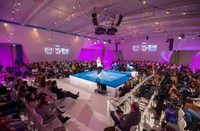 Royal Jaarbeurs plenary stage with 360-degree layout and bistro lighting for corporate events.