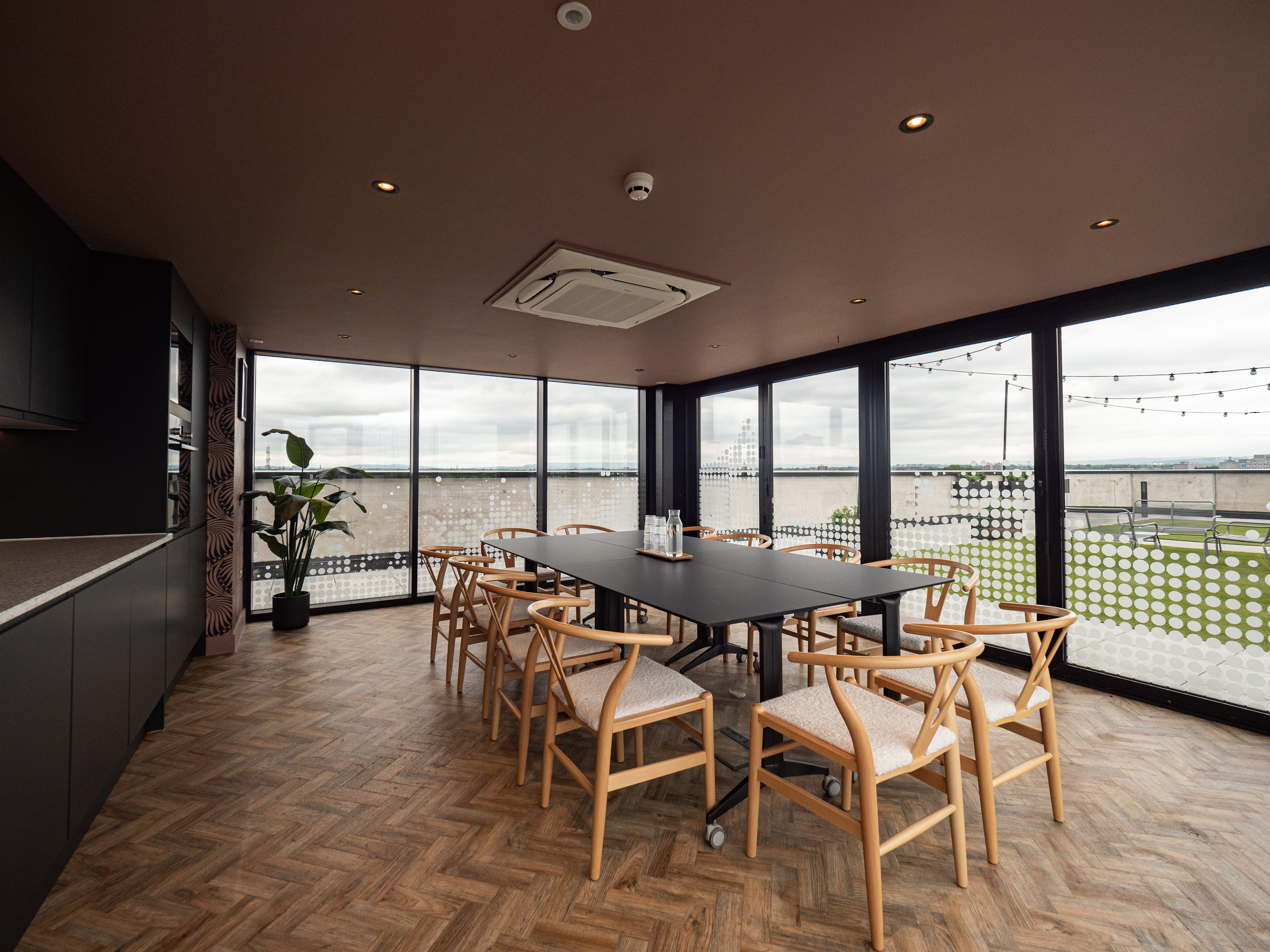 Modern meeting space at The Observatory, featuring large windows and cozy seating.
