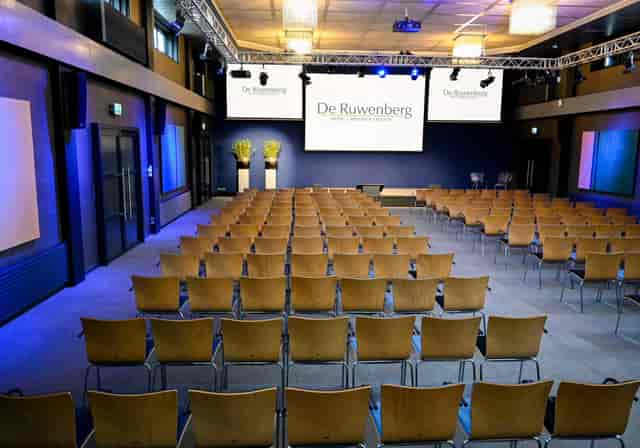 De Ruwenberg atrium conference hall with triple-screen AV for corporate events and plenary meetings.