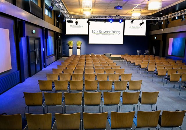De Ruwenberg atrium conference hall with triple-screen AV for corporate events and plenary meetings.