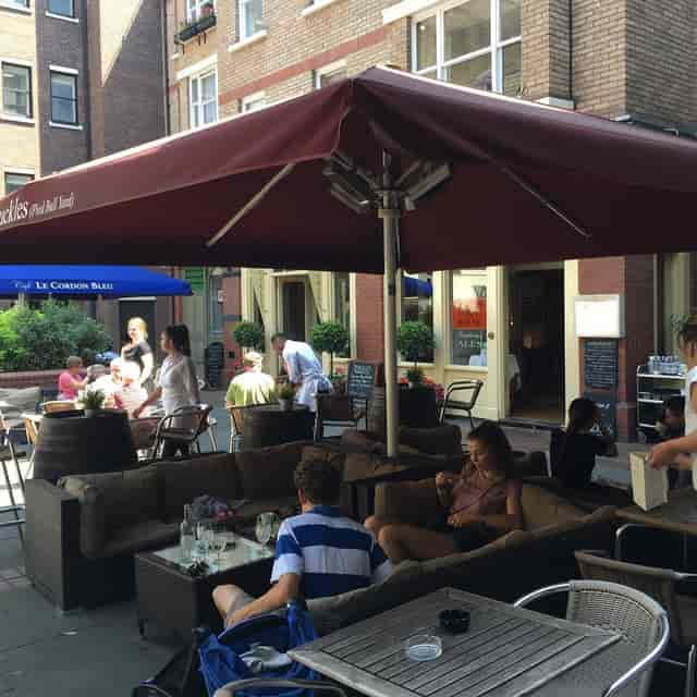 Outdoor venue at The Port House with umbrella seating for casual meetings and events.