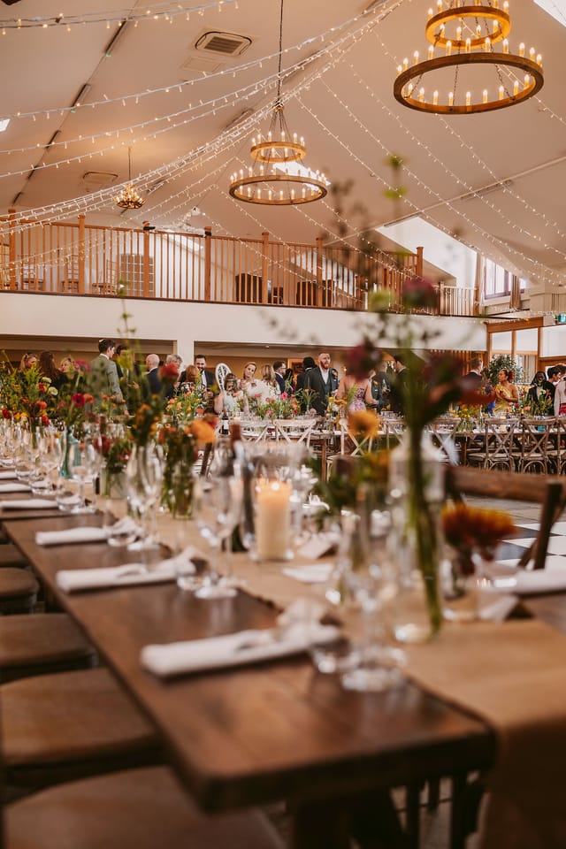 Elegant event space with flower-adorned tables perfect for weddings and celebrations.