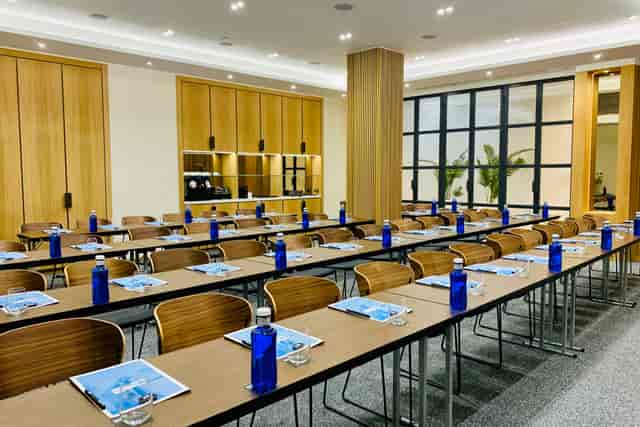 Modern workshop space at H10 London Waterloo with branded blue water bottles.