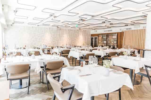 Elegant corporate luncheon venue in Corpo Santo Lisbon Hotel with modern geometric lighting.