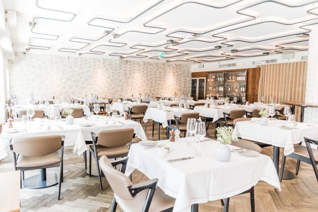 Elegant corporate luncheon venue in Corpo Santo Lisbon Hotel with modern geometric lighting.