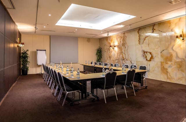 U-shape White Plains boardroom at Sheraton Lisboa with marble walls for corporate business meetings.
