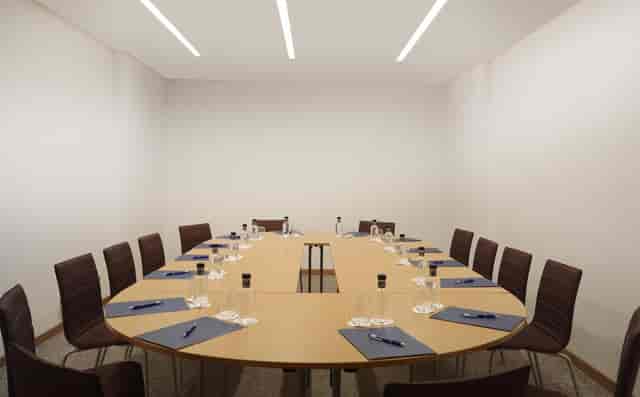 Organized meeting room with oval table, ideal for corporate events and brainstorming sessions.