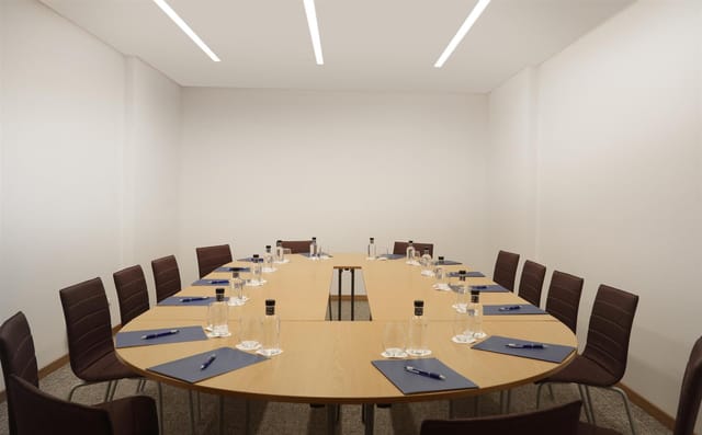 Organized meeting room with oval table, ideal for corporate events and brainstorming sessions.