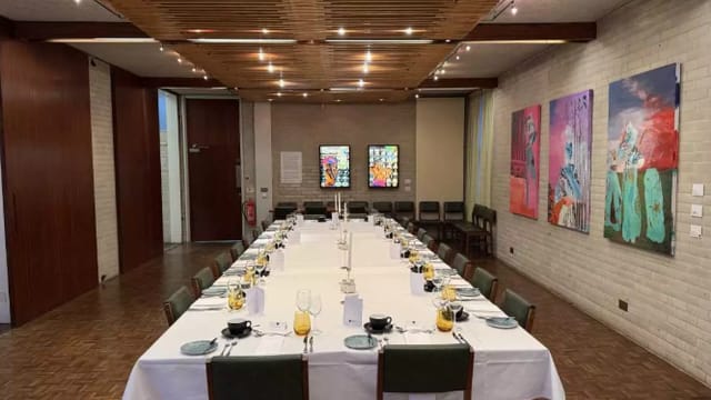 Murray Edwards Fellows Suite: Formal banquet table, modern art, executive event.