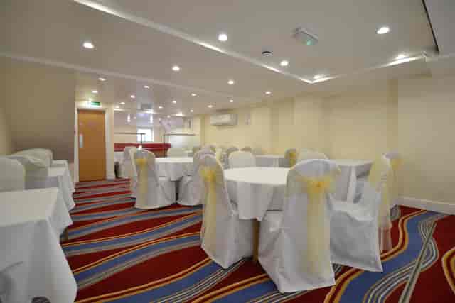 London hotel banquet hall, formal round tables, event space.