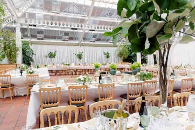 Botanical wedding banquet hall, natural light, greenery, elegant event