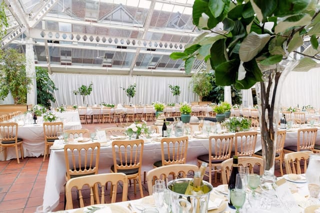 Botanical wedding banquet hall, natural light, greenery, elegant event