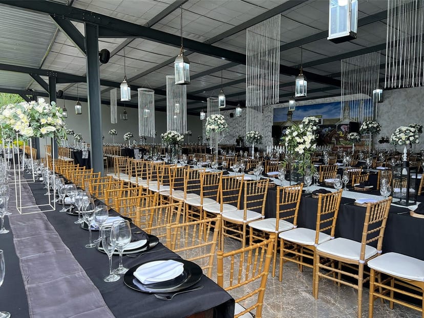 Elegant wedding venue, black linens, gold chairs