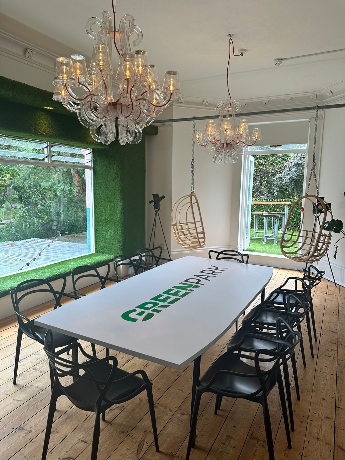 Biophilic glass boardroom with hanging seats for creative corporate meetings and office events. - Banner