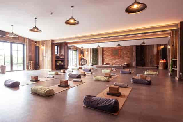 Rustic Main Barn yoga retreat space with floor seating for wellness events and mindfulness workshops.
