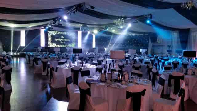 Gala setup at Bath Pavilion with elegant black-and-white linens and professional stage lighting.