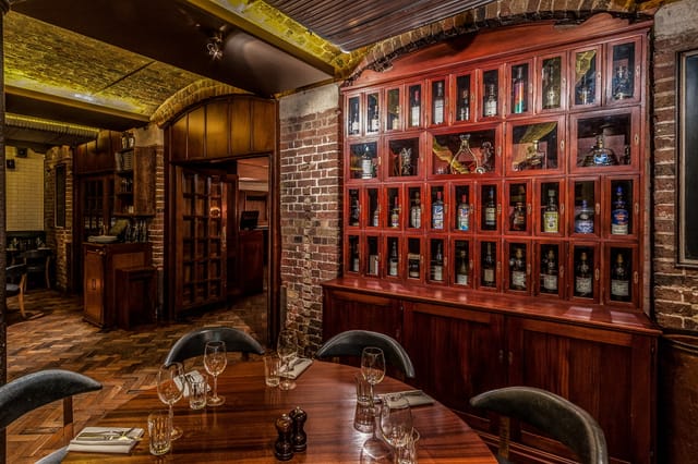 Private dining room at Hawksmoor Seven Dials with wood textures for VIP dinners and board meetings.