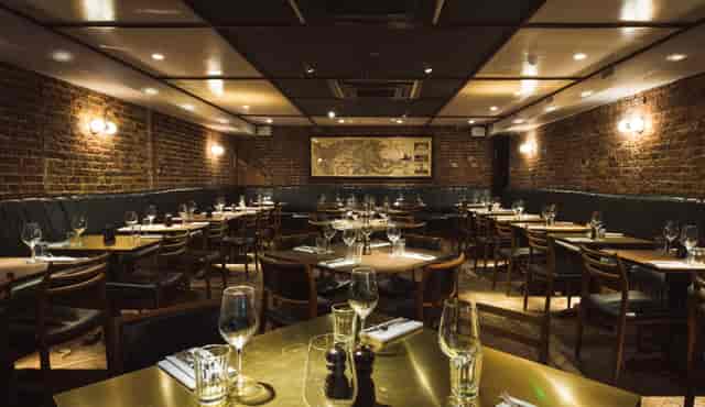 Hawksmoor Spitalfields Bar: rustic brick interior for corporate events and networking mixers.