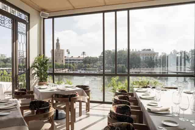 Riverfront corporate luncheon venue at Río Grande Sevilla with natural light for VIP dinners.