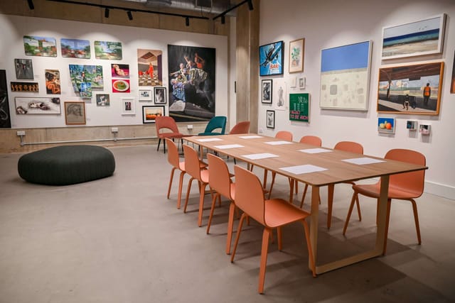 Minimalist gallery boardroom for creative workshops and strategy sessions.