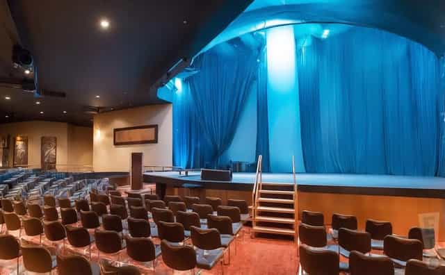 Boulder Station theater venue with blue-lit stage for corporate events and keynote presentations.